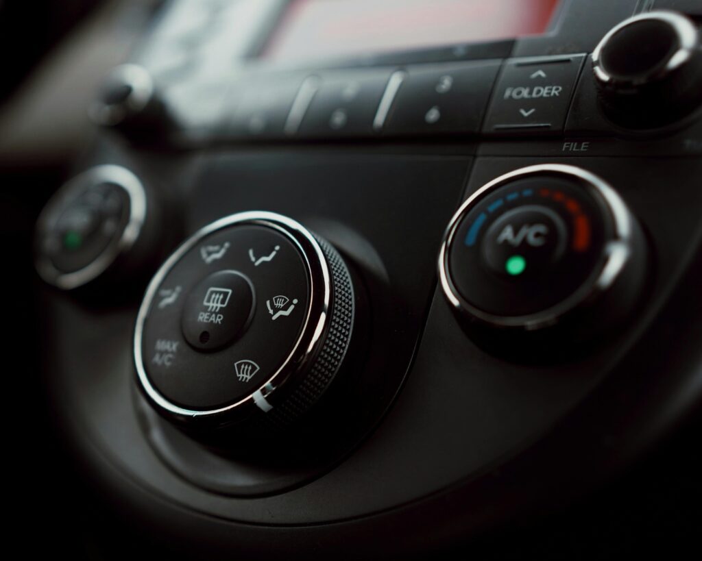 Detailed close-up of car dashboard air conditioning controls with focus on buttons and dials.